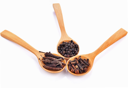 Cloves, black pepper, long pepper  in spoon wooden on white background