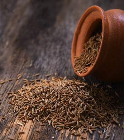 Cumin seeds heap on table wooden background