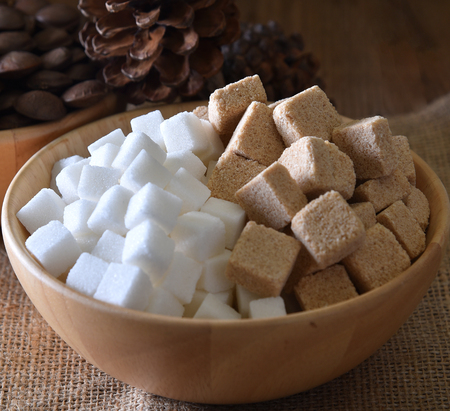 Sugar cubes white ,sugar cubes cane in wood bowl on wooden backgroundの写真素材