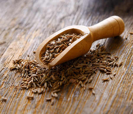 Cumin seeds in spoon wood on table woodenの写真素材