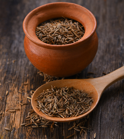 Cumin seeds in spoon wood on table wooden backgroundの写真素材