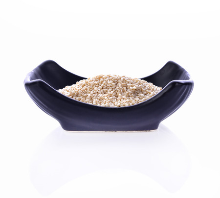 White Sesame Seeds in bowl black on white backgroundの写真素材