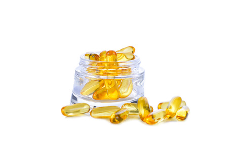 Omega 3 capsules for the concept of fasting in a glass cup on a white background.の写真素材