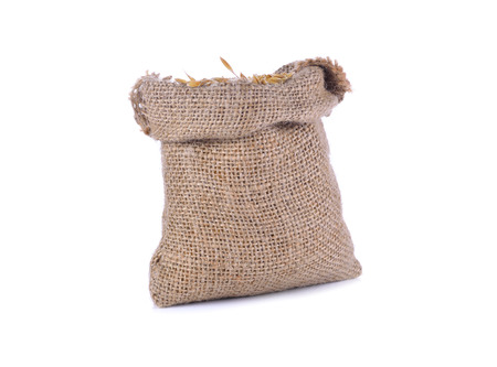 Hemp sack with brown paddy rice seed on white background.の写真素材