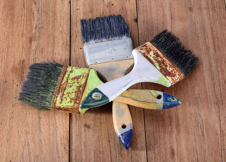 dirty paint brushes on isolated on woodの写真素材