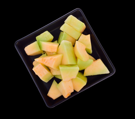 Melon slices on a black plate Isolated on Black Background.の写真素材