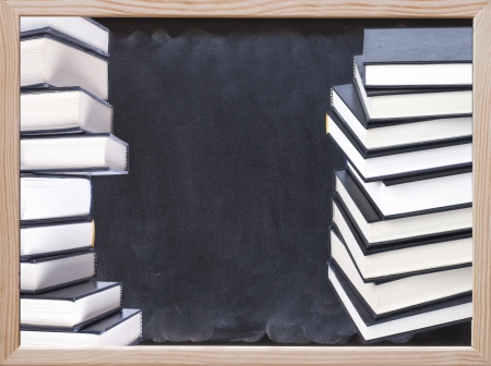 Stacks of hardcover books with blackboard backgroundの写真素材