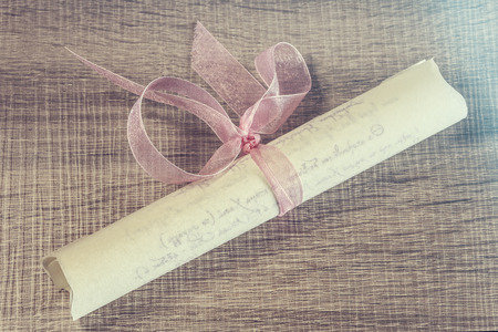 Invitation with pink ribbon. Cross processed image with selective focusの写真素材