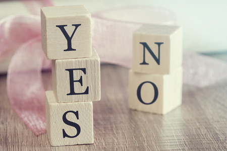 Proposal concept. Wooden blocks forming Yes and No words. Cross processed image with selective focusの写真素材