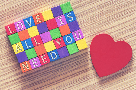 Love concept. Valentines day background with Love quote written in colorful wooden blocks. Cross...