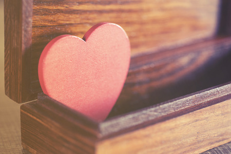 Valentine's red heart in a box. Love concept. Selective focus image cross processed for vintage lookの写真素材
