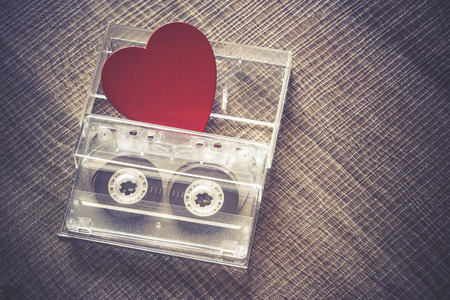 Love music concept. Valentines day background with audio tape cassette and a red heart. Cross processed image with shallow depth of fieldの写真素材