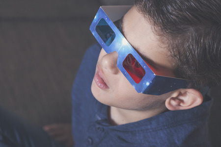 Little boy watching a 3D movie. Vintage effect image with shallow depth of fieldの写真素材