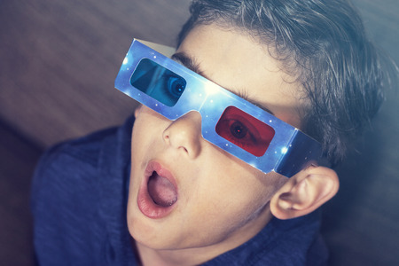 Little boy reacts while watching a 3D movieの写真素材