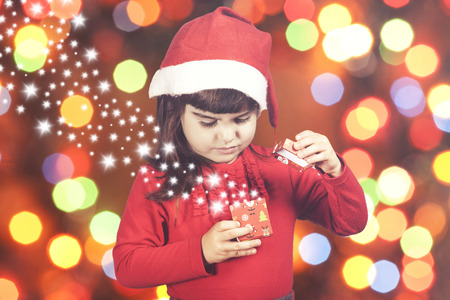 Sweet little Santa girl opening her Christmas presentの写真素材