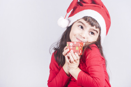 Sweet little girl holding a Christmas gift boxの写真素材