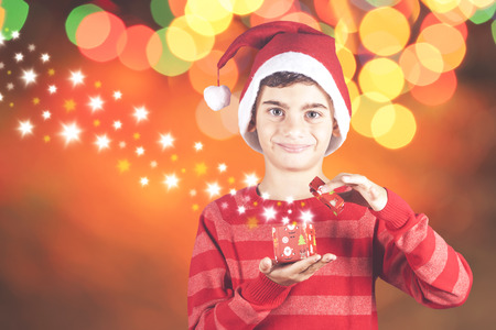 Little Santa boy opening his Christmas presentの写真素材