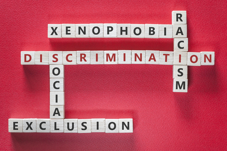 Discrimination, xenophobia, racism and social exclusion words written with blocks on red background. Social issues conceptの写真素材
