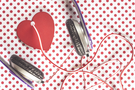 Love music concept with headphones and red heart on vintage polka dots background. Table top viewの写真素材
