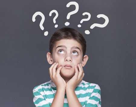 Boy with question marks over his head. Dilemma and decision making concept