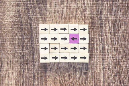 Uniqueness, difference, individuality and standing out from the crowd concept with purple arrow...
