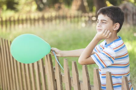 Young boy with ballÎ¿on outdoors. Childhood conceptの写真素材