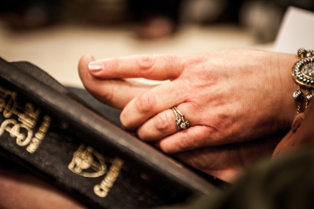 Holding hands on a Bibleの写真素材