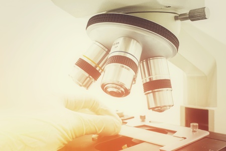 Microscope with scientist hand isolated on the white background