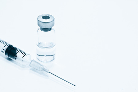 Vial of Drug or Vaccine and 3 ml Plastic Syringe with Needle Isolated on the White Background, blue tone colorの写真素材