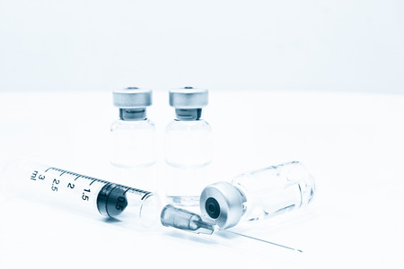 Vial of Drug or Vaccine and 3 ml Plastic Syringe with Needle Isolated on the White Background, blue...