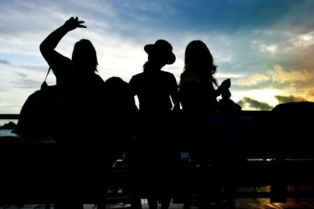 The silhouette of three women at balcony before sunriseの写真素材