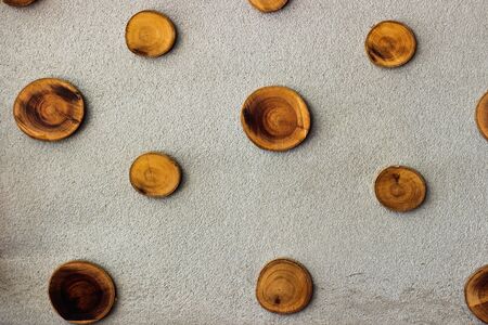 The round wood pieces on cement wall