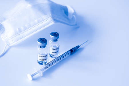 Covid-19 Prevention concept : vial of Covid-19 vaccine, 1 ml plastic syringe with needle and mask