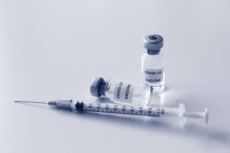 Vial of Covid-19 vaccine and 1 ml plastic syringe with needle isolated on the white background
