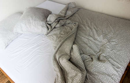 Mattress, blanket and pillows after waking up.