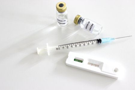 Vial of Covid-19 vaccine, 1 ml plastic syringe with needle and Positive test result of Covid-19...