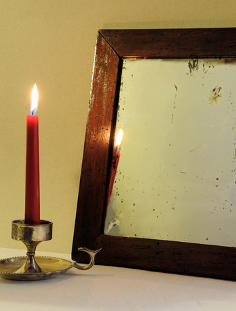 Red candle and antique mirrorの写真素材