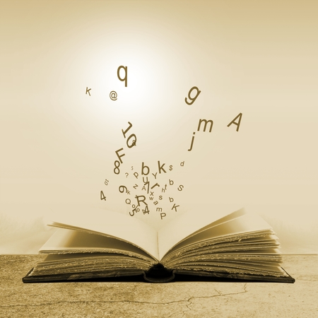Open book with lightbulb and letters. Concept of the importance of reading. Sepia tones.の写真素材