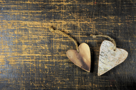 Two wooden heart on scratched wooden table. Love concept.の写真素材