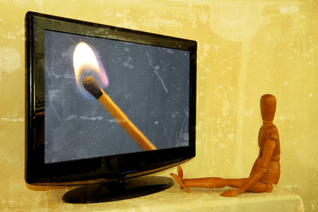 Dummy painter in front of television with lit matchの写真素材