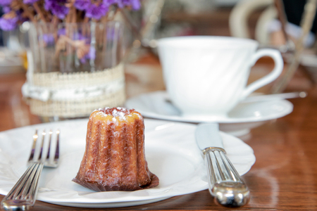 Small piece of canele serve in a plate on the table in tea shopの写真素材