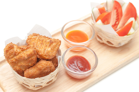 Fried chicken nuggets serve with tomato, cucumber and saucesの写真素材