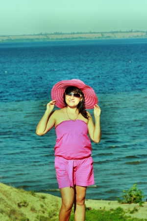 A beautiful young brunette standing on the beachの写真素材