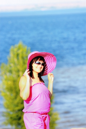Young brunette in a suit and sunglasses on the beachの写真素材