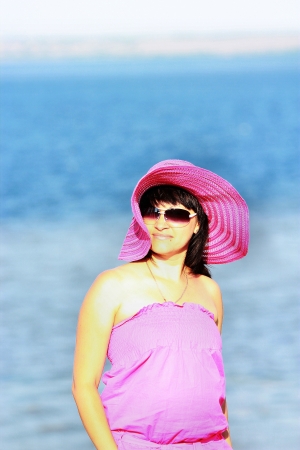 A girl in a pink dress on a background of waterの写真素材
