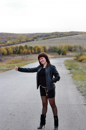 Girl voted by the road catches the carの写真素材