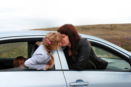 Mother and daughter kissing in the carの写真素材