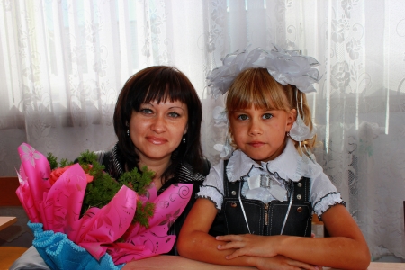 Mom and daughter first grader at a school deskの写真素材