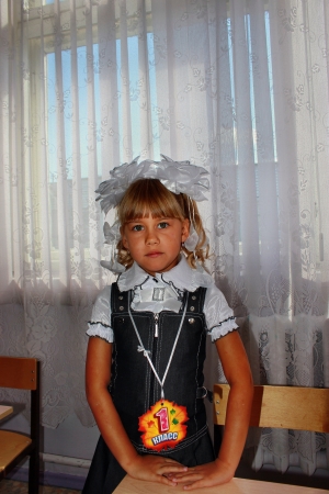 Girl with ribbon bows first class standing near the deskの写真素材