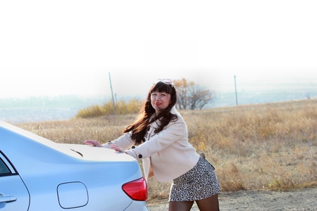 Long-haired girl pushing a carの写真素材